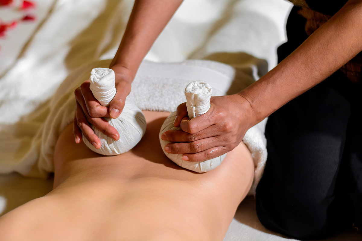 Thai massage with hot herbal compresses. Back massage.